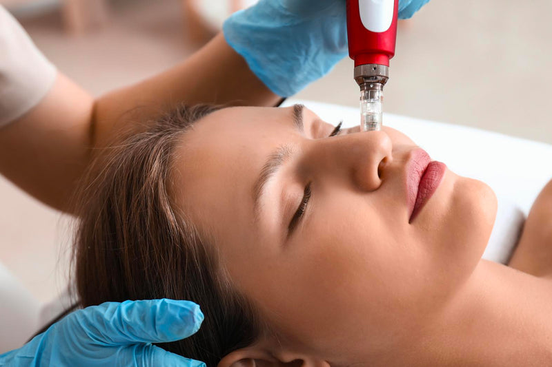 Esthetician performing a BBGlow procedure on a woman's face to reduce imperfections